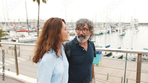 Happy middle aged couple walking in the city on summer day, retired elderly couple enjoy outdoor recreation together