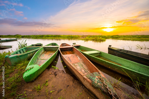 Fototapeta Naklejka Na Ścianę i Meble -  Zachód słońca na rzece z łodziami