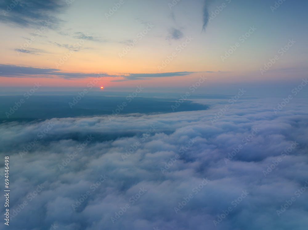 Aerial view above the clouds at sunrise