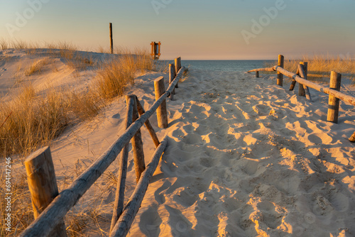 Wejście na plażę nad morze ocean o zachodzie słońca