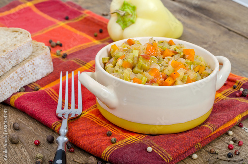 Bowl with hot vegetable stew with zucchini on a napkin