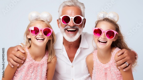 Happy Father's Day concept, busy father organizes holiday on International children's day for two daughters, have home party, wear wreath and fashion sunglasses. photo