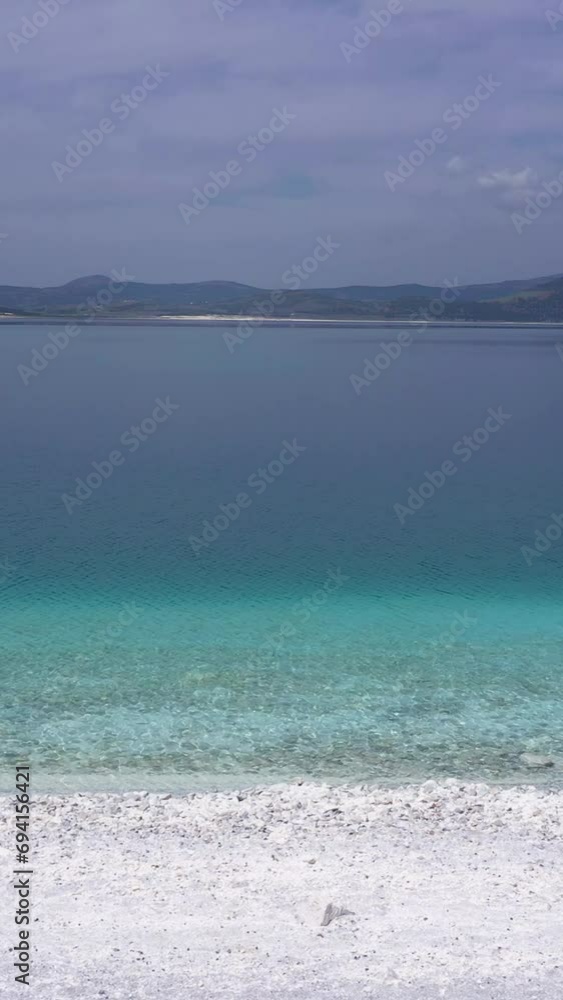Lake Salda Coastline on Sunny Day. Crater Lake. Burdur Province, Turkey. Aerial View. Turkish Maldives. Drone Flies Sideways at Low Level. Slider Shot. Vertical Video Lake Salda Coastline on Sunny Day. Crater Lake. Burdur Province, Turkey. Aerial View. Turkish Maldives. Drone Flies Sideways at Low Level. Slider Shot. Vertical Video