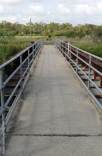 Concrete bridge in a park with grass and trees