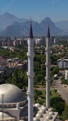 White Mosque, Cityscape and Mountains. Antalya, Turkey. Aerial View. Drone Flies Backwards and Upwards. Vertical Video photo