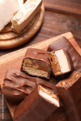 Tasty chocolate bars with nougat on table  closeup