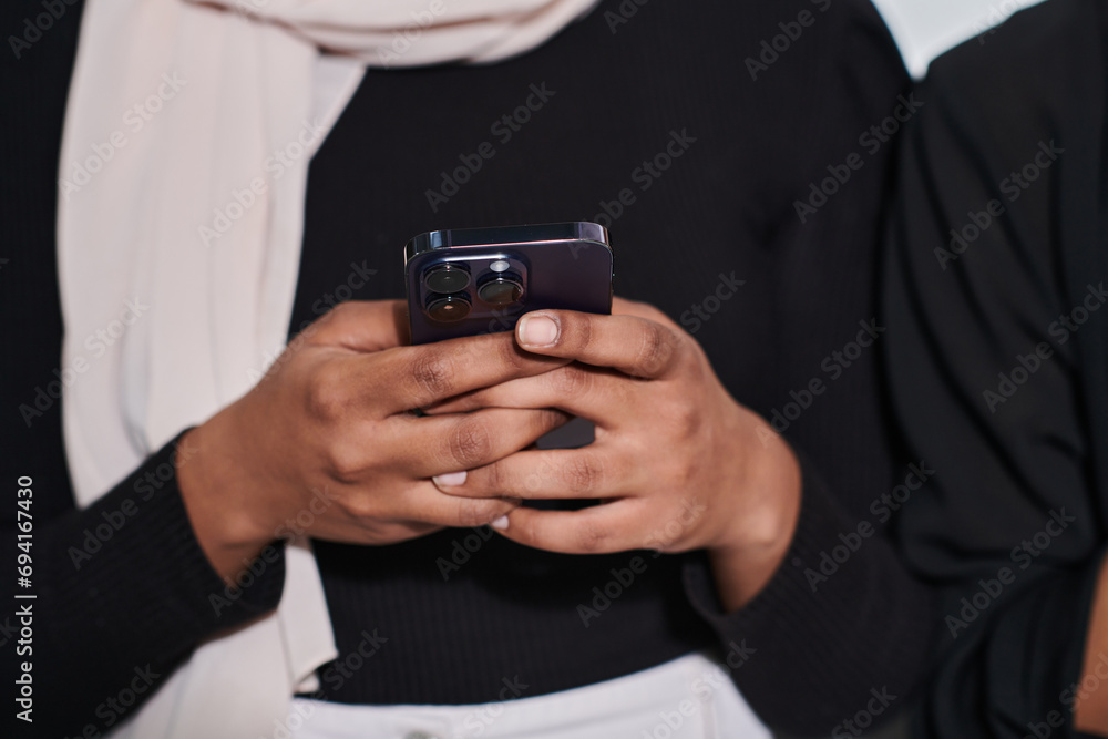 Captured in a close-up moment, a girl in hijab skillfully engages with her smartphone, reflecting a contemporary lifestyle where digital connectivity seamlessly intertwines with cultural expression Captured in a close-up moment, a girl in hijab skillfully engages with her smartphone, reflecting a contemporary lifestyle where digital connectivity seamlessly intertwines with cultural expression