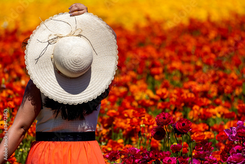 Girl standing in field of colorful flowers