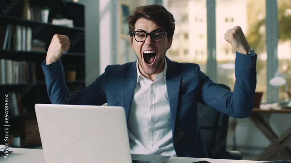 Fototapeta premium A young businesswoman in front of a laptop cheerfully celebrates success