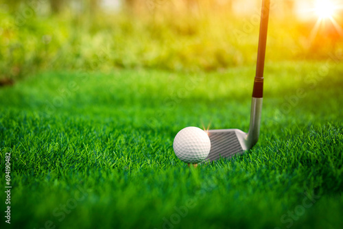 Golf ball close up on tee grass on blurred beautiful landscape of golf background. Concept international sport that rely on precision skills for health relaxation.