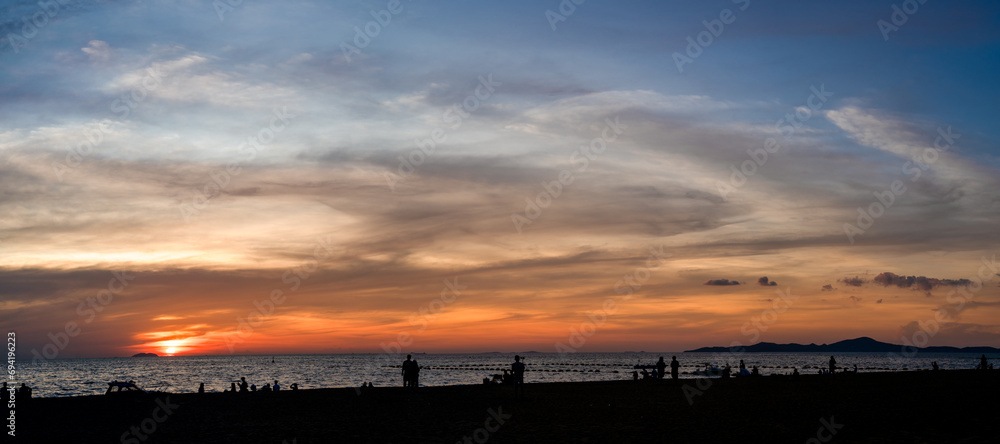 Panoramic beautiful colorful golden hour twilight sky. silhouettes, people meet sunset in tropics, Thailand, Pattaya. Beautiful cloud and sky nature background in magic hour