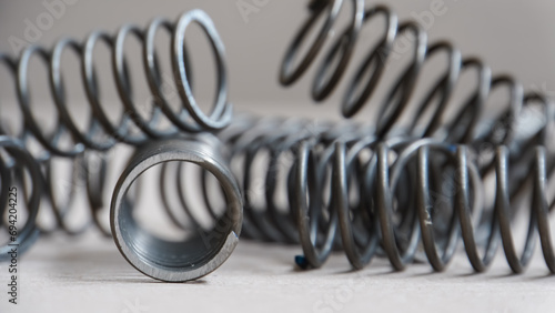 Coiled metal spring on metal surface, close-up view photo
