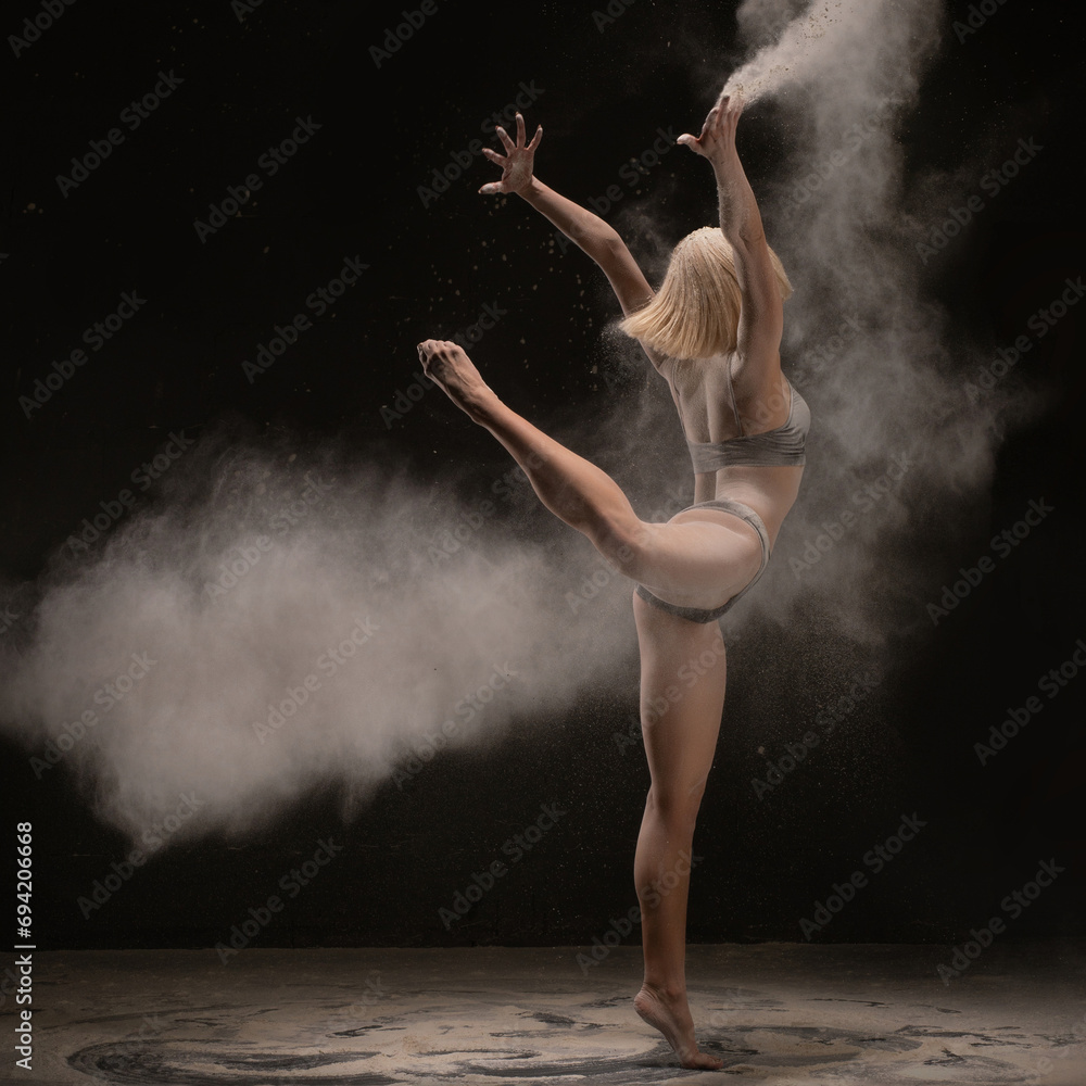 Slim dancer being enveloped in white powder cloud