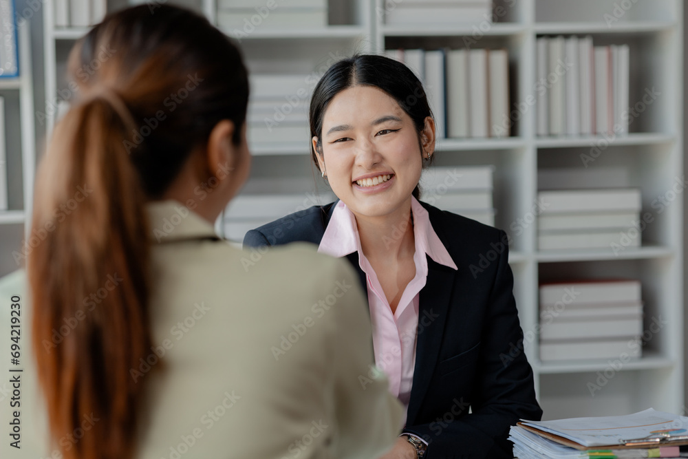 Confident female professional discussing with colleagues, Professional business executive managers working using laptop computer sitting at table, discussing digital strategy at corporate meeting.