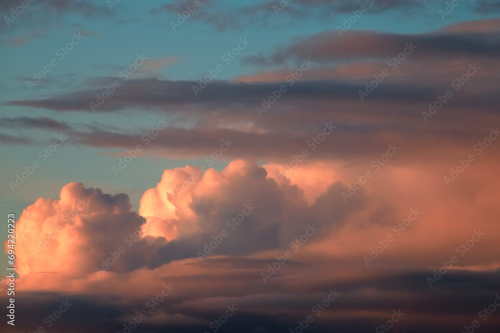 Naklejka premium Cloud landscape in delicate pastel shades of pink and blue at sunset, romantic wallpaper, space for text, weather observation, nature after summer rain.