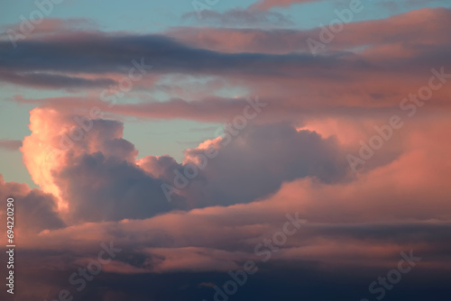 Cloud landscape in delicate pastel shades of pink and blue at sunset, romantic wallpaper, space for text, weather observation, nature after summer rain.