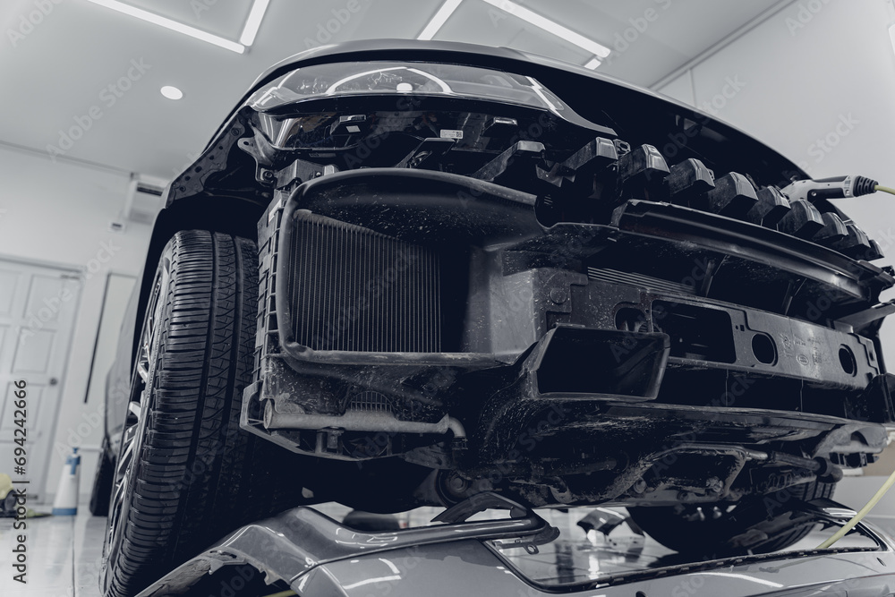 Replacing spare parts on a disassembled car in a car service garage Replacing spare parts on a disassembled car in a car service garage