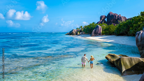 Anse Source d'Argent beach La Digue Island Seychelles, a couple of men and woman walking at the beach at a luxury vacation. a couple swimming in the turqouse colored ocean of La Digue Seychelles photo