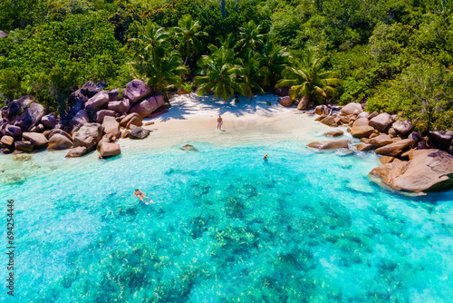 Anse Lazio Beach Praslin Seychelles tropical island with white beaches and palm trees, a couple of men and women mid age on vacation at Seychelles photo