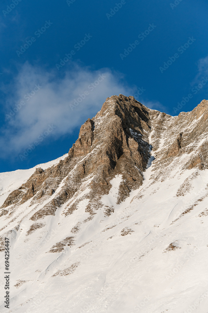 Beautiful mountain landscape, snowy slope with a peak without snow