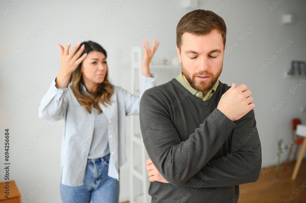 Family quarrel, man and woman sitting on sofa at home. angry woman yells at her husband Family quarrel, man and woman sitting on sofa at home. angry woman yells at her husband
