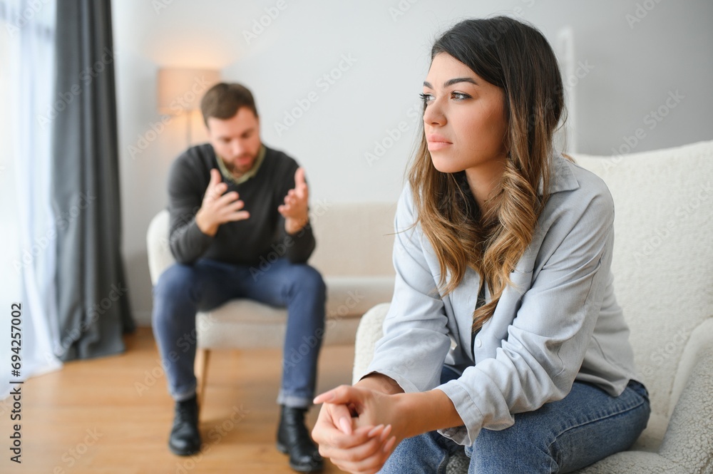 Emotional man gesturing and shouting at his wife, young couple having quarrel at home. Domestic abuse concept Emotional man gesturing and shouting at his wife, young couple having quarrel at home. Domestic abuse concept