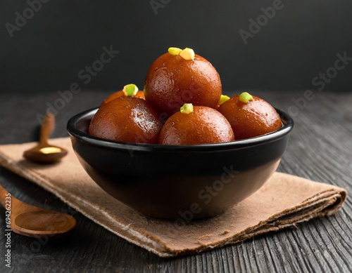 sweet gulab jamun served in black ceramic bowl photo
