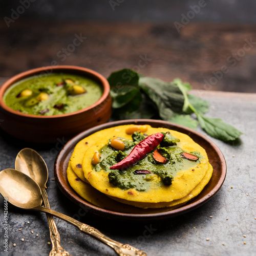 makki di roti with sarson ka saag, popular punjabi main course recipe in winters made using corn breads mustard leaves curry. served over moody background photo
