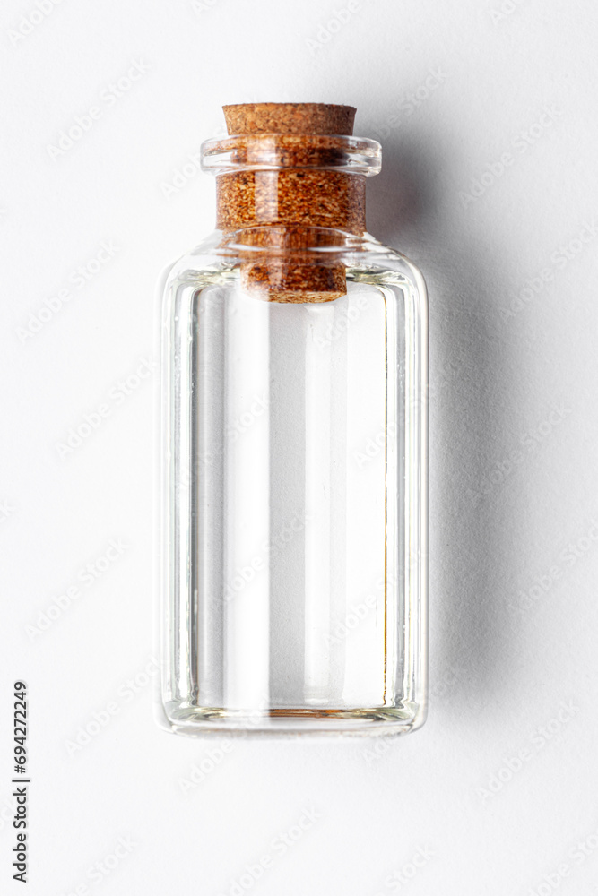 Top-down view of a round glass bottle containing clear transparent essential oil for cosmetics and natural medicine. Top-down view of a round glass bottle containing clear transparent essential oil for cosmetics and natural medicine.