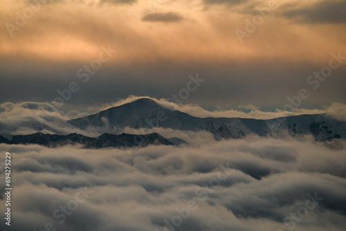 Several peaks of the mountain massif are shrouded in thick fog © fesenko