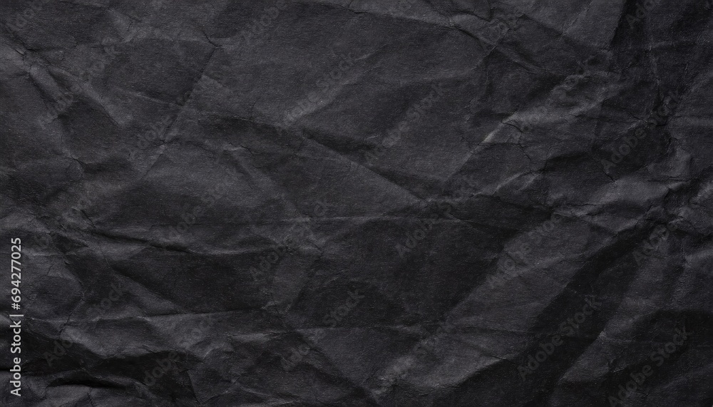 A black crumpled paper background. A black crumpled paper background.