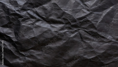 A black crumpled paper background. photo