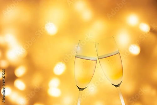Sektgläser und Flasche vor Verschwommenen Geldenen Lichtern mit Bokeh-Effekt