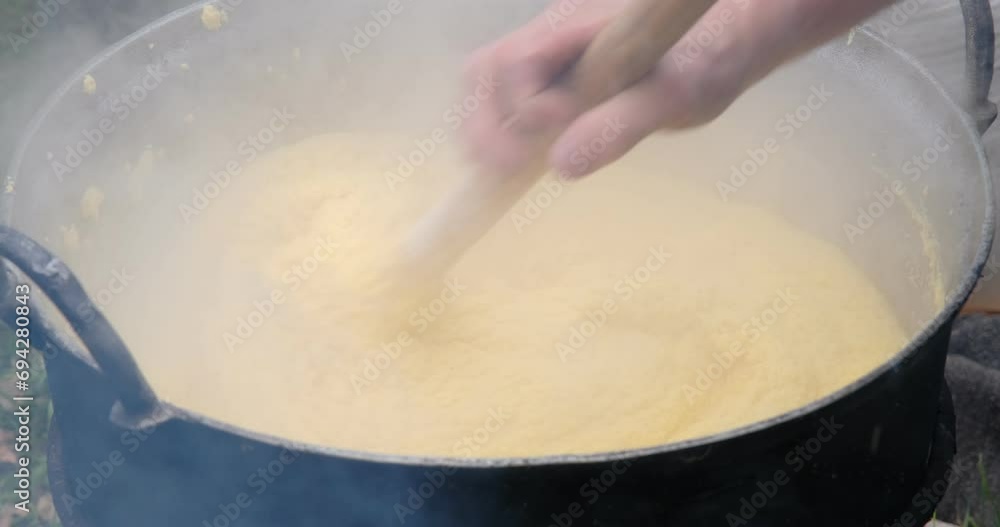 Preparation of polenta in a cauldron on the open fire Preparation of polenta in a cauldron on the open fire