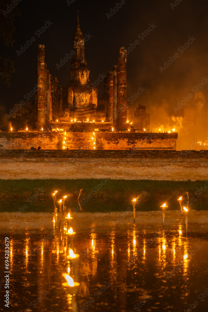 Wat Mahathat illuminated by candlelight.