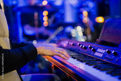 Musician playing electric piano in event with blue colored background photo