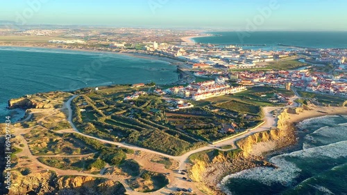 Pull back revealing drone shot Peniche, town, cliffs and sunset