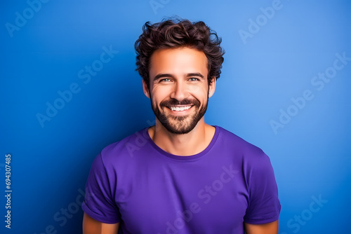 Homme brun avec barbe souriant sur un fond violet