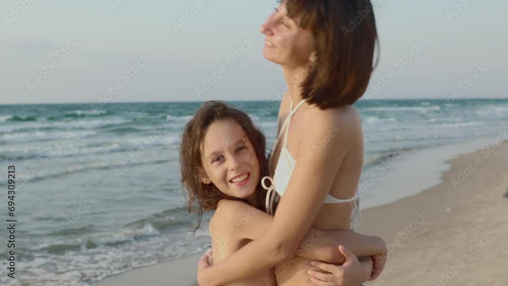 mother and son relax on the beach. happy family together. mother hugs her son. mother and son relax on the beach. happy family together. mother hugs her son.
