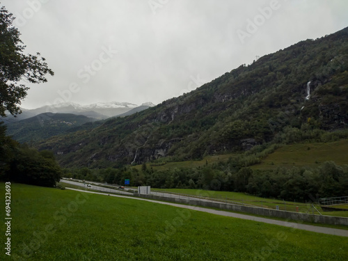 view of green mountains and the road nearby in the rain, fog on the mountains