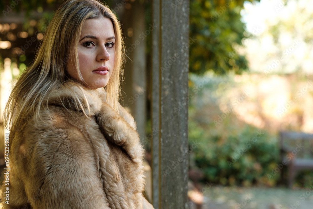 Nostalgic caucasian woman looking at camera in a park. Nostalgic caucasian woman looking at camera in a park.