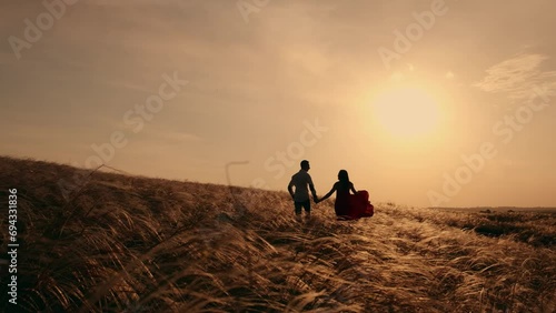 Silhouette of a man and woman at sunset, in slow motion. Love story, happy family. Romantic date and love in nature of loving happy couple photo