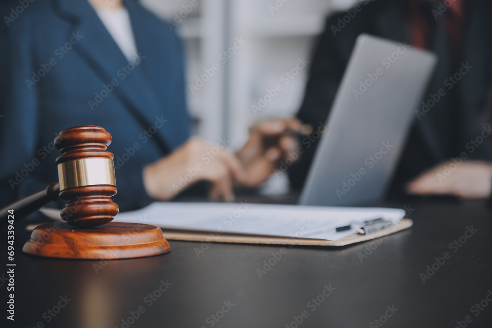 Business and lawyers discussing contract papers with brass scale on desk in office. Law, legal services, advice, justice and law concept picture with film grain effect Business and lawyers discussing contract papers with brass scale on desk in office. Law, legal services, advice, justice and law concept picture with film grain effect