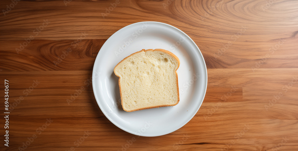 bread on wooden table, top down shot of a piece of white bread on a plate bread on wooden table, top down shot of a piece of white bread on a plate