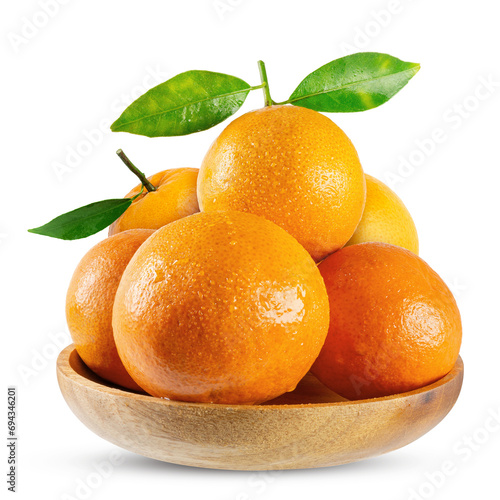 Ripe yellow tangerines with green leaves in wooden bowl isolated on white background