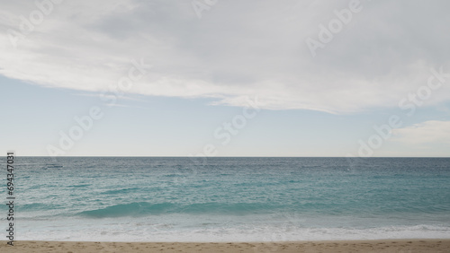 Clear blue waves with strong wind on a sandy empty beach in Cannes in spring