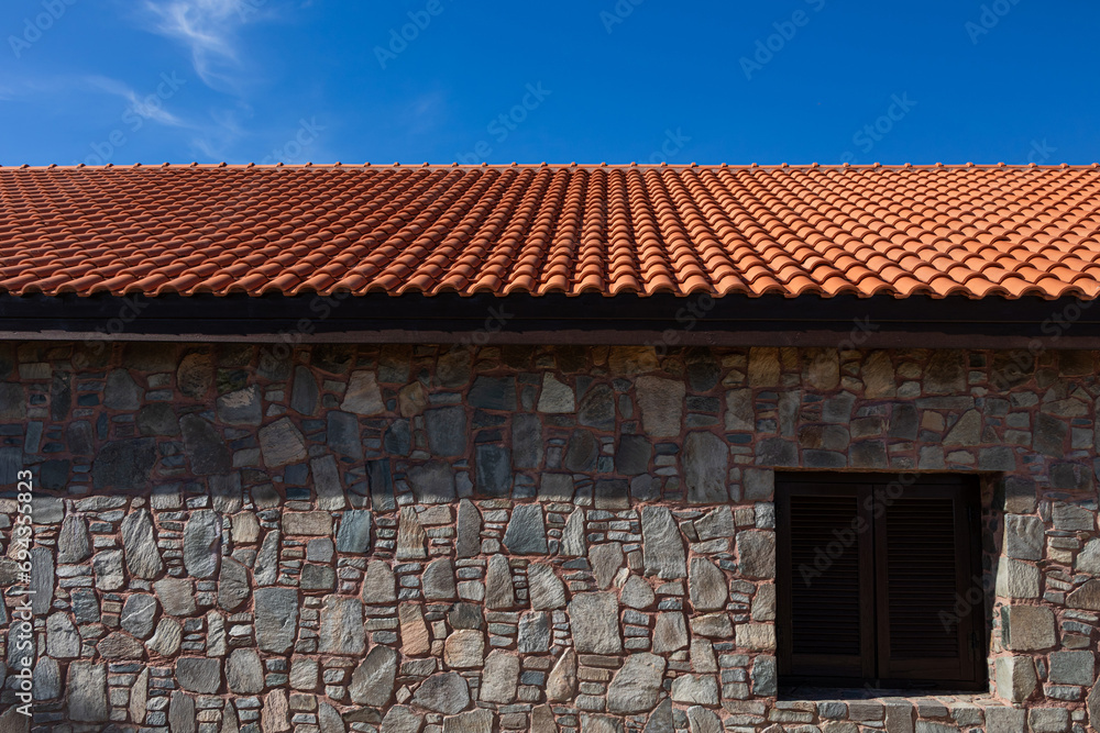 An old building with stone walls and a new clay tile roof. Restoration of historical buildings