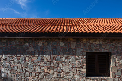 An old building with stone walls and a new clay tile roof. Restoration of historical buildings © Armands photography