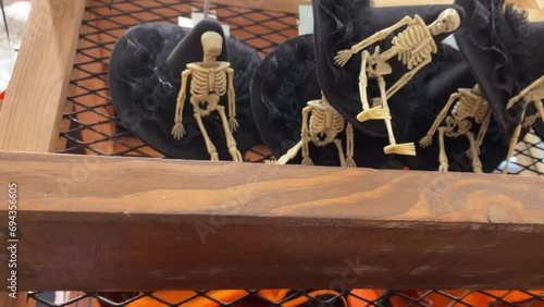 4k video footage of Shop that sells house decoration for Halloween such as Jack-o-lantern pumpkins, spider webs, monsters, zombie, ghosts, skulls bones, skeletons and wizard witch magician cone hats. photo