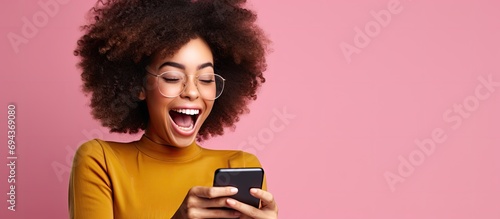 Excited woman impressed by social media feedback on smartphone. photo